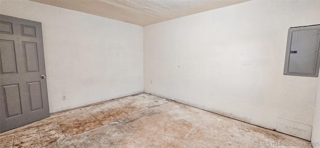 empty room featuring electric panel and a textured ceiling