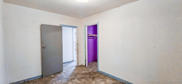 interior space featuring concrete floors, a textured ceiling, and a closet