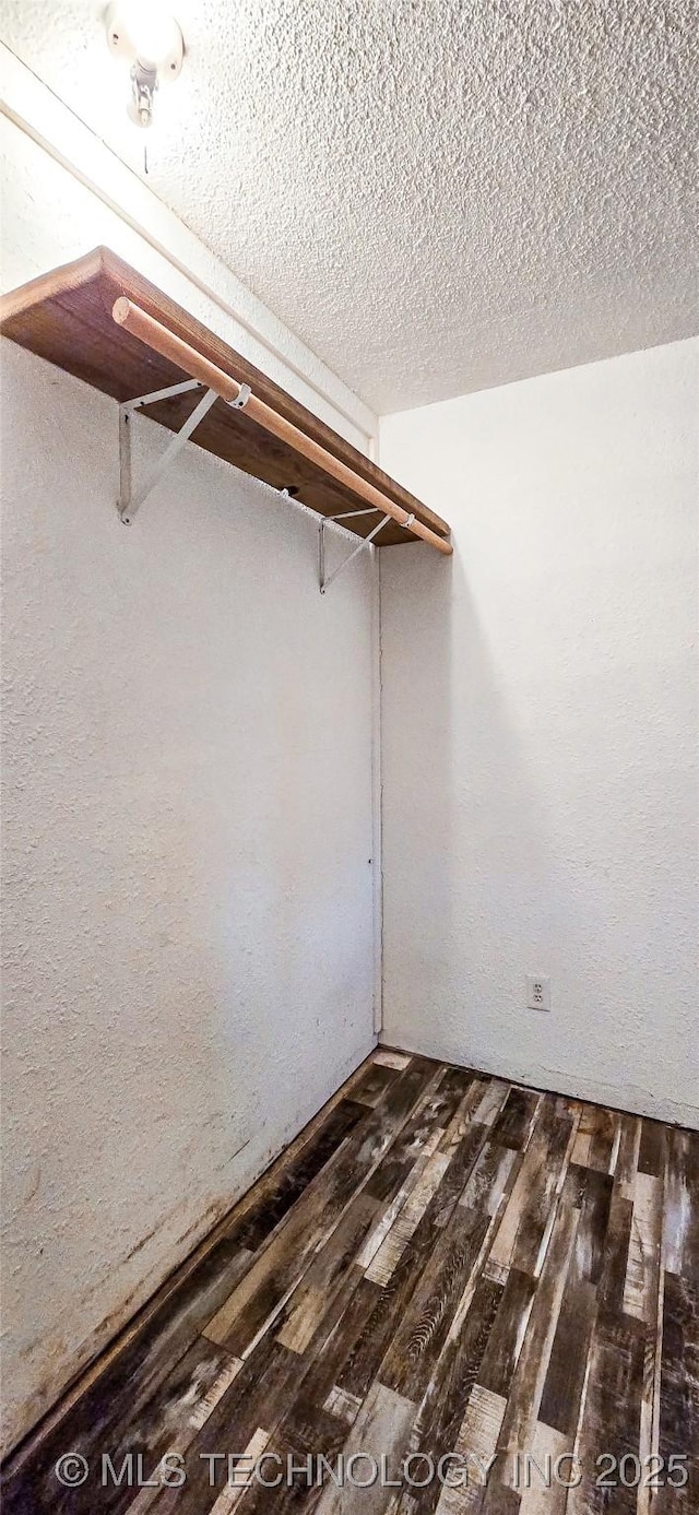 walk in closet with dark wood-type flooring