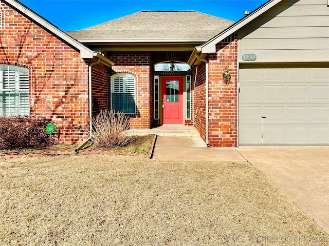 property entrance featuring a garage and a lawn