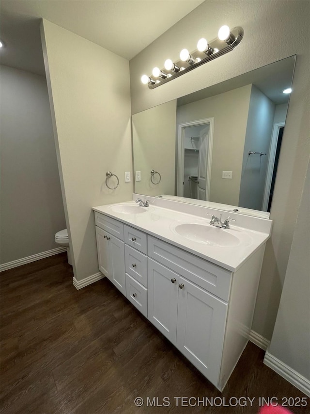 bathroom featuring vanity, wood-type flooring, and toilet