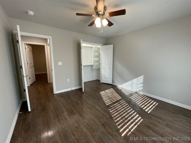 unfurnished bedroom with ceiling fan, dark hardwood / wood-style flooring, and a closet