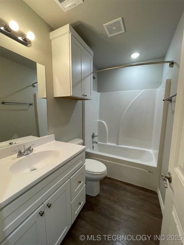 full bathroom featuring vanity, hardwood / wood-style floors, shower / bathtub combination, and toilet