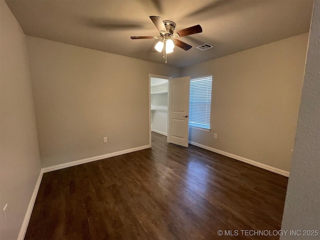 spare room featuring ceiling fan and dark hardwood / wood-style flooring