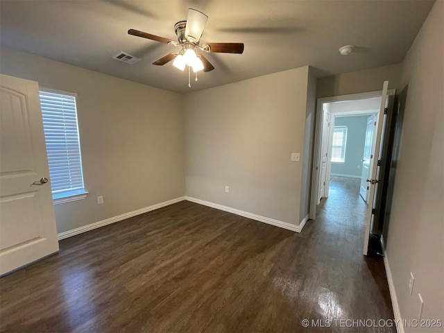 unfurnished room featuring dark wood-type flooring and ceiling fan