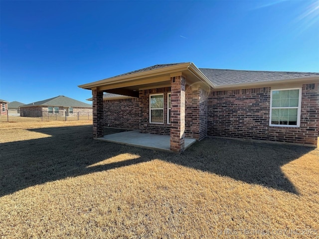 view of side of property with a yard and a patio area