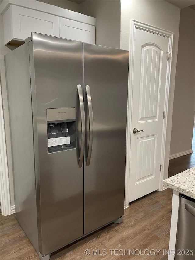 kitchen featuring light stone counters, stainless steel appliances, wood-type flooring, and white cabinets