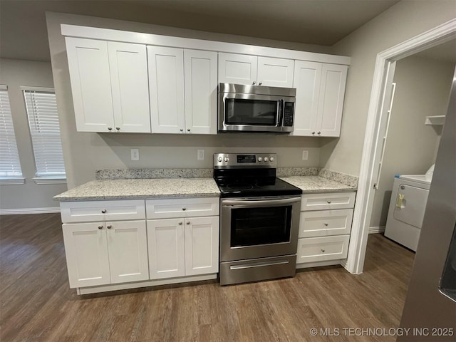 kitchen featuring stainless steel appliances, light stone counters, white cabinets, dark hardwood / wood-style flooring, and washer / clothes dryer