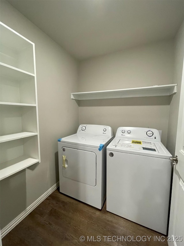 laundry room featuring washing machine and clothes dryer and dark hardwood / wood-style flooring