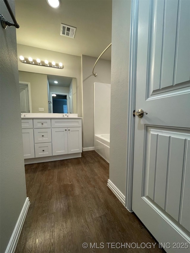 bathroom featuring vanity, hardwood / wood-style floors, and shower / bathing tub combination