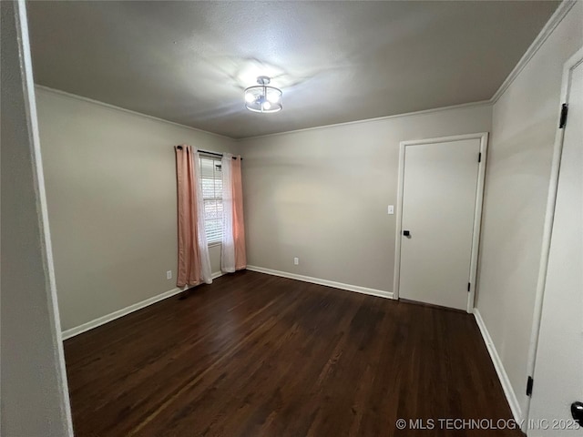 spare room with ornamental molding and dark hardwood / wood-style floors