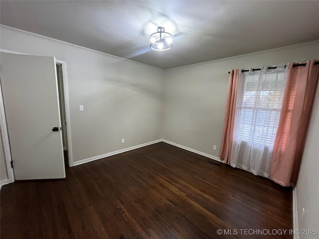 unfurnished room featuring crown molding and dark wood-type flooring