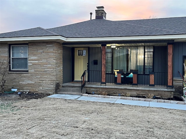 exterior entry at dusk featuring covered porch