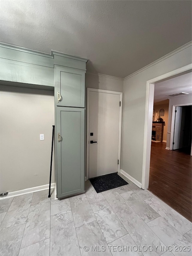 interior space featuring ornamental molding and a textured ceiling