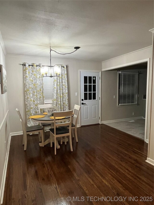 unfurnished dining area with a notable chandelier, crown molding, and dark hardwood / wood-style floors