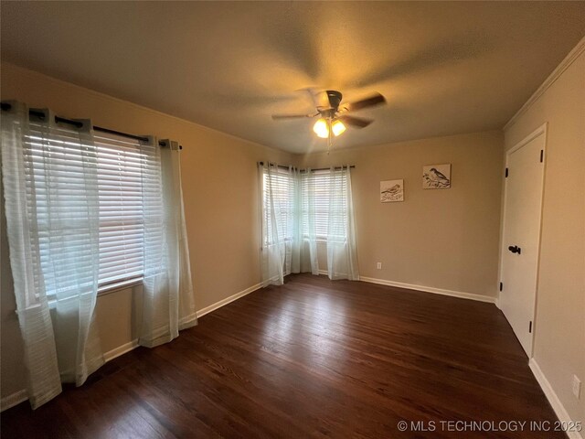 empty room with dark hardwood / wood-style flooring and ceiling fan