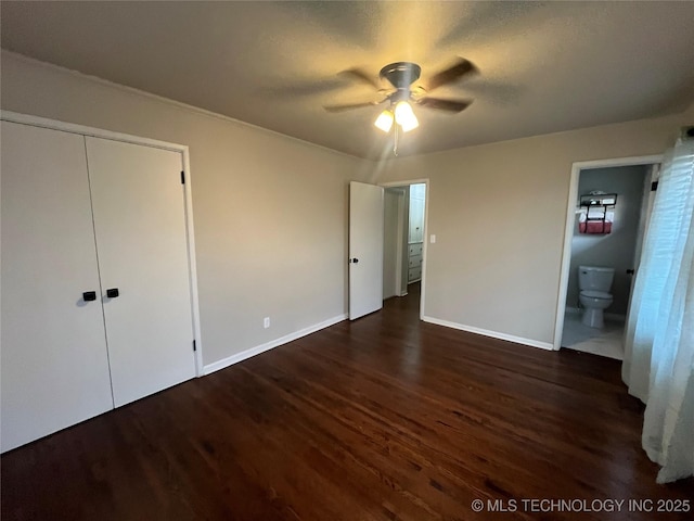 unfurnished bedroom featuring dark hardwood / wood-style flooring, ensuite bath, a closet, and ceiling fan