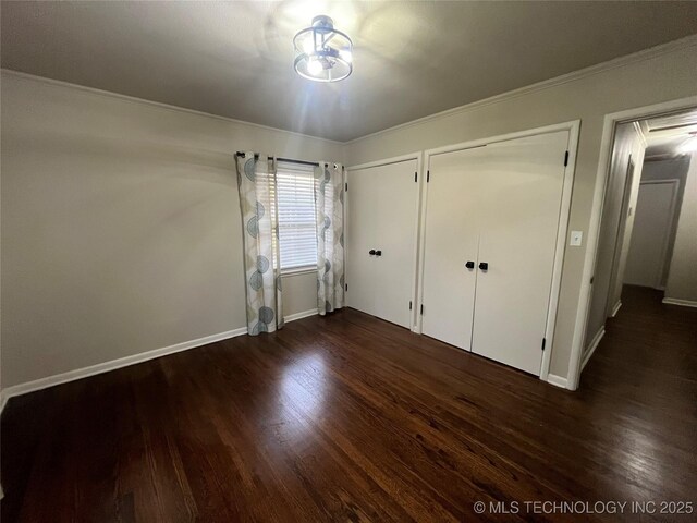 unfurnished bedroom featuring ornamental molding and dark hardwood / wood-style flooring