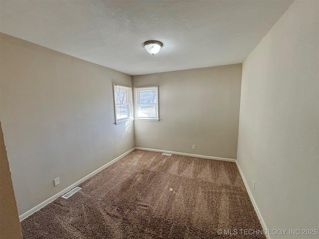 carpeted spare room featuring a textured ceiling