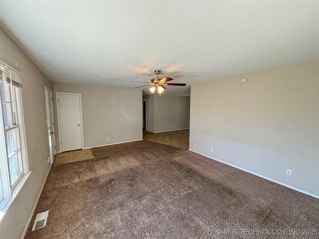 spare room featuring carpet, a wealth of natural light, and ceiling fan