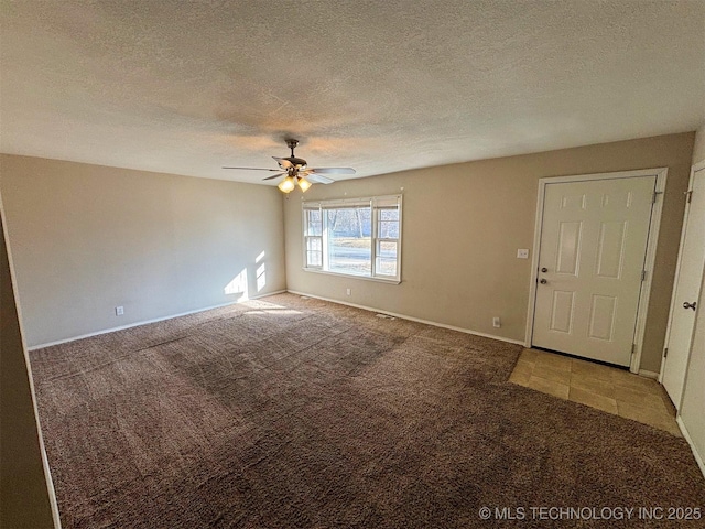 spare room featuring ceiling fan, carpet floors, and a textured ceiling