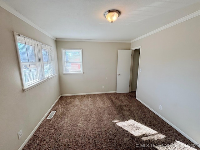 empty room featuring crown molding and carpet floors