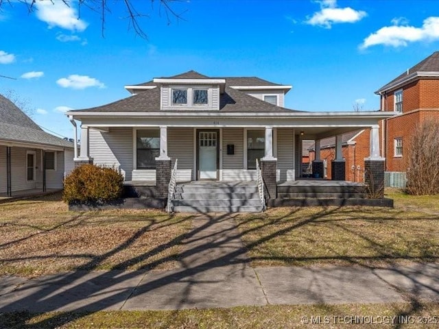 view of front of home with covered porch and a front lawn