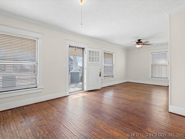 spare room with a textured ceiling, ornamental molding, dark hardwood / wood-style floors, and ceiling fan