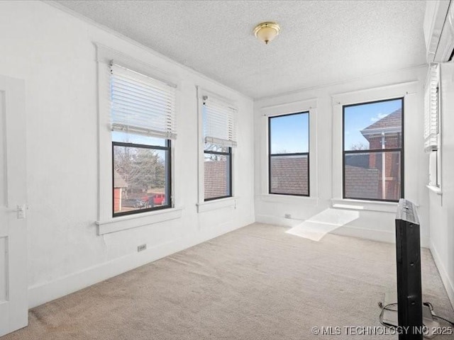 carpeted spare room featuring a textured ceiling