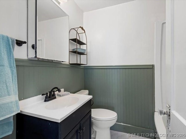 bathroom with vanity, a tub to relax in, wooden walls, and toilet