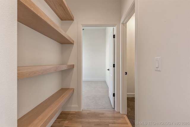 corridor with light hardwood / wood-style floors