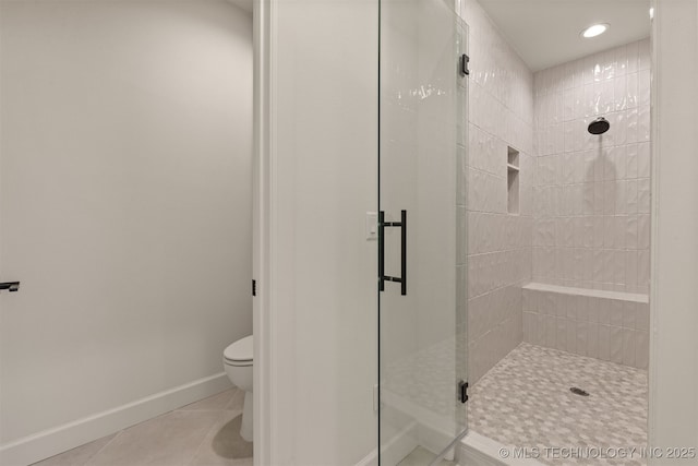 bathroom featuring walk in shower, tile patterned floors, and toilet