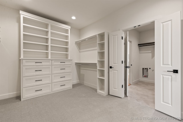 spacious closet featuring light carpet and heating unit