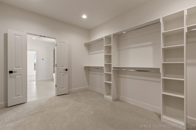 walk in closet featuring light colored carpet