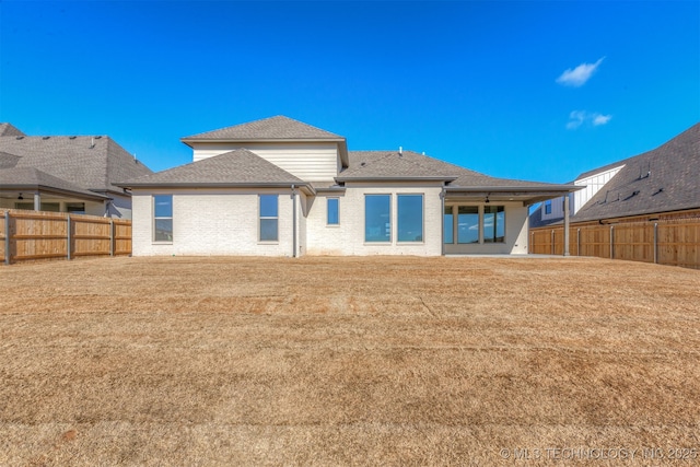 rear view of property with a patio and a lawn