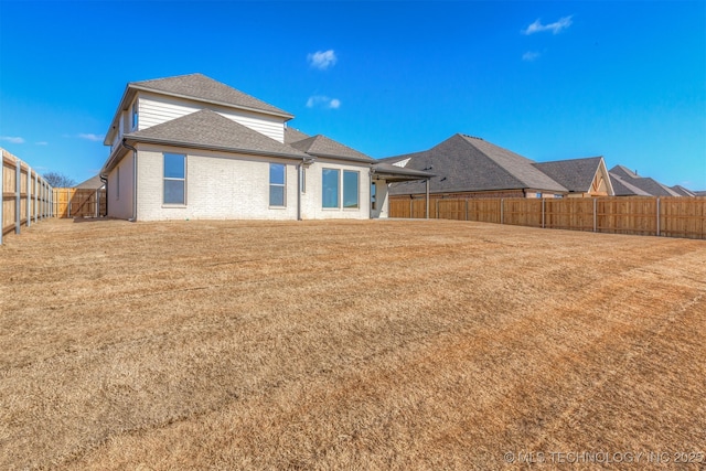 rear view of house featuring a yard