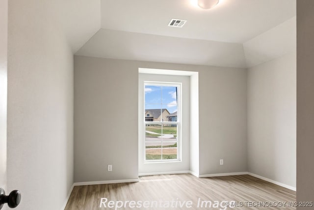 unfurnished room with lofted ceiling and light hardwood / wood-style flooring