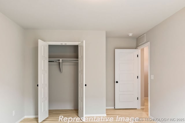 unfurnished bedroom with light hardwood / wood-style floors and a closet