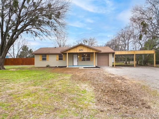 ranch-style house with a garage, a front yard, and a carport