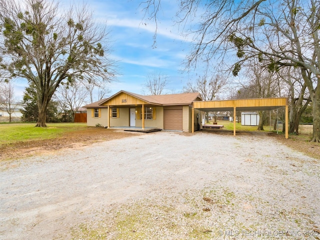 single story home with a porch, a garage, a carport, and a front lawn