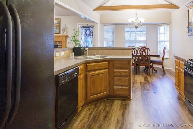 kitchen with stainless steel refrigerator, decorative light fixtures, dishwasher, vaulted ceiling with beams, and sink