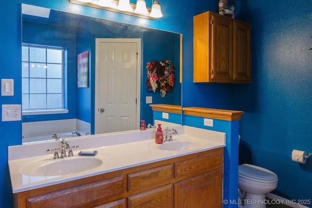 bathroom featuring vanity, toilet, and a tub to relax in