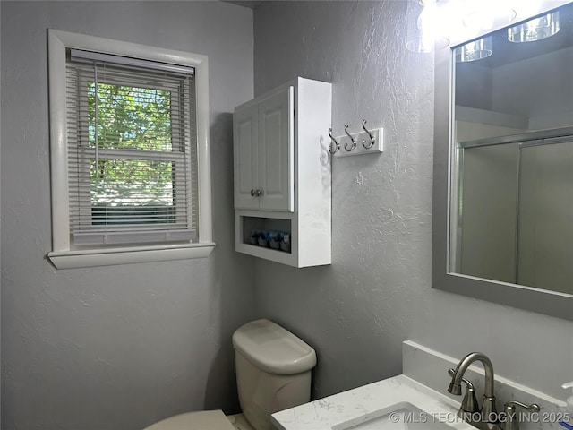 bathroom featuring vanity, toilet, and an enclosed shower