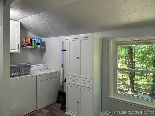 laundry room with cabinets, dark hardwood / wood-style floors, independent washer and dryer, and a textured ceiling