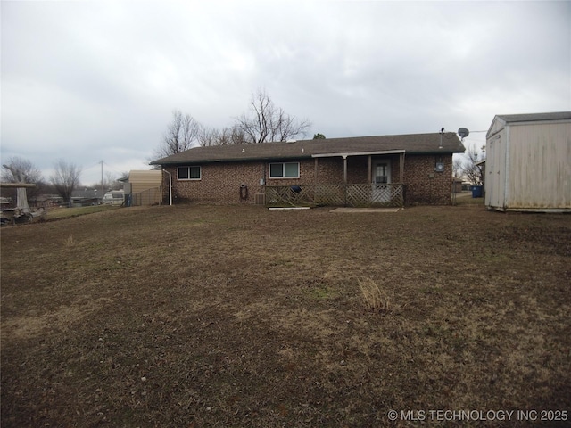 back of house with a shed and a lawn