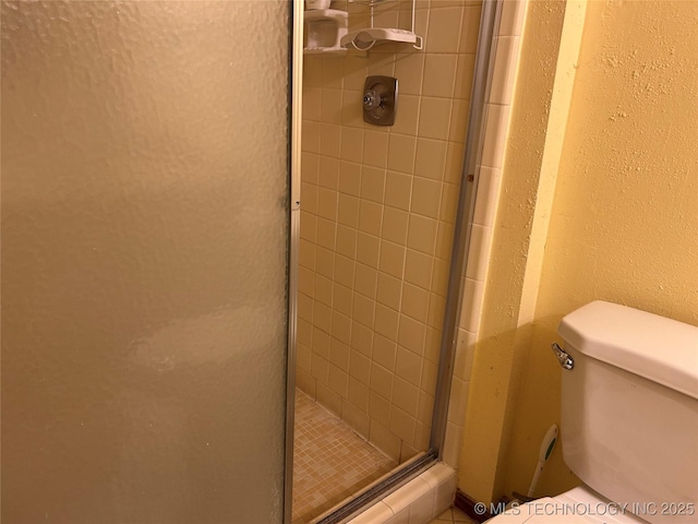 bathroom featuring walk in shower and toilet