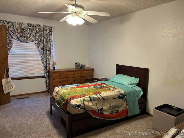 carpeted bedroom featuring a textured ceiling and ceiling fan