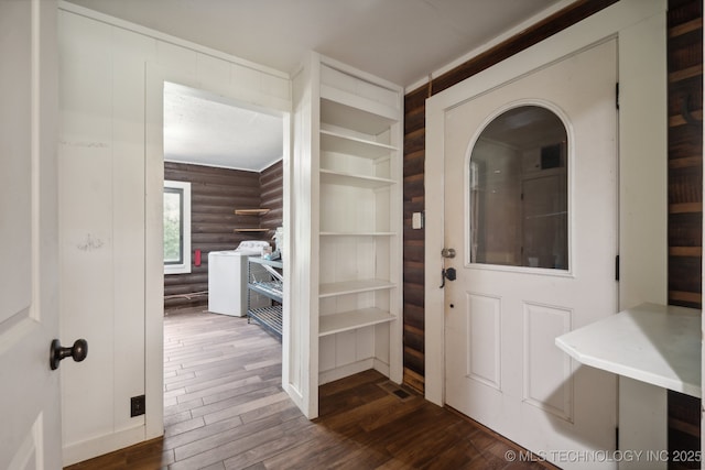 foyer entrance featuring washer / clothes dryer, dark wood-type flooring, and log walls