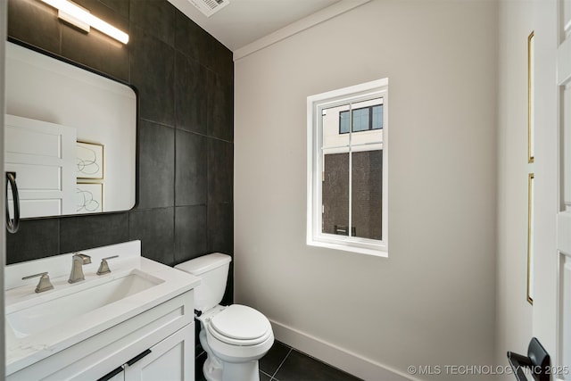 bathroom featuring vanity, toilet, tile patterned flooring, and tile walls