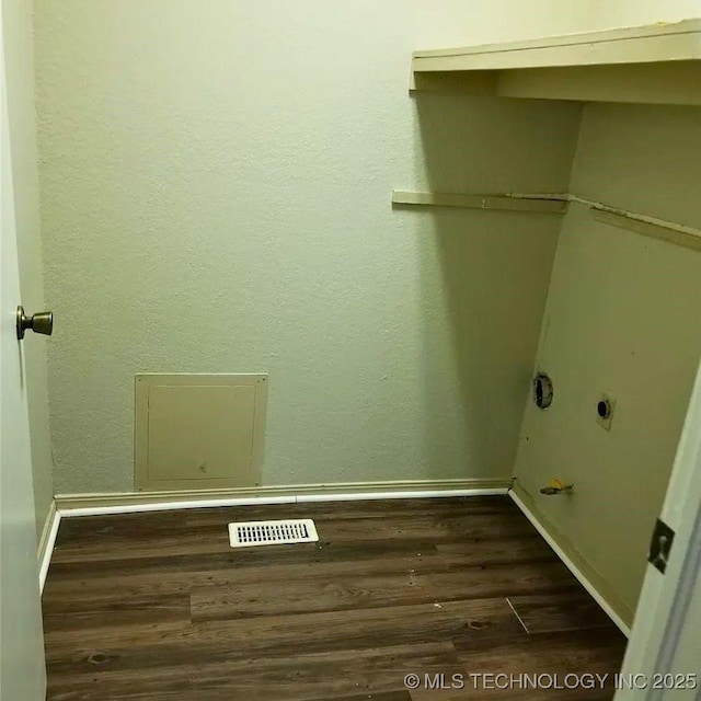 laundry area with electric dryer hookup and dark wood-type flooring